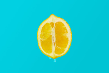 Juicy lemon slices on blue paper table top view. Flat lay