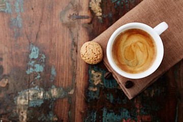 Cup of coffee on rustic wooden background. Top view. Copy space.