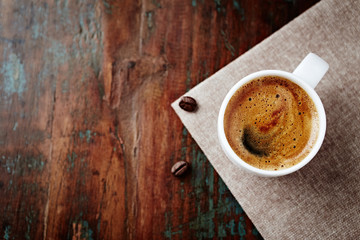 Cup of coffee on rustic wooden background. Top view. Copy space. 