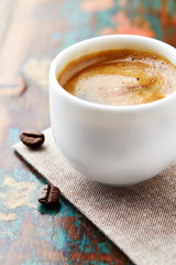 Cup of coffee on rustic wooden background. Close up. 