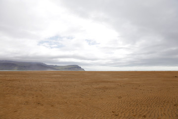 Fototapeta na wymiar Orange sand beach in Iceland. Rauðisandur (Red Beach) is a 10 kilometer stretch of a beach on the south coast of the West Fjords in Iceland. 