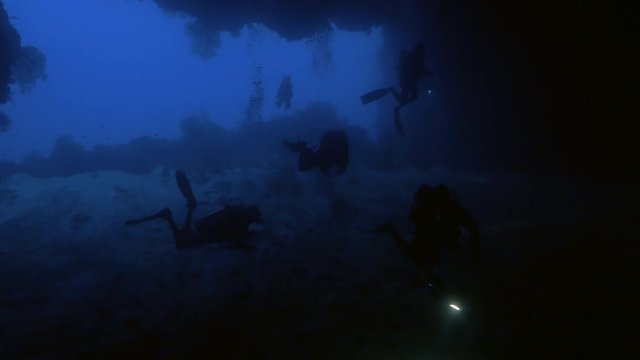 Group of Scuba divers inside giant under water cave, Palau