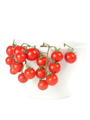closeup of a bunch of cherry tomatoes in a cup with white background