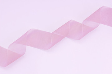 pink folded ribbon in the form of a spiral on a pink background