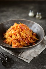 Braised cabbage with ham, onions and carrots. Traditional Russian food.