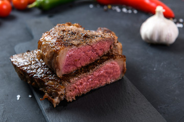 Grilled beef steak ribeye rare on on dark background