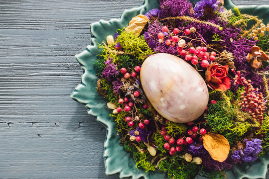 Purple Stone Egg Nestled with Dried Botanicals on Turquoise Plate