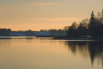 Yellow landscape with lake water trees plants sunset water view reflections, beautiful sky clouds calm leisure