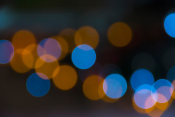 Blur bokeh of Christmas lights, balls, blue and yellow on a dark background