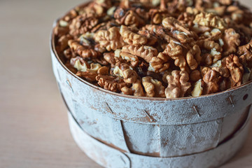 Cracked clean walnuts in rustic bowl. Copy space. Top view. 
