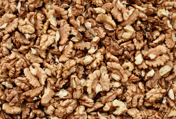 Cracked walnuts background. Seamless pattern. Close up.