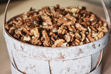 Cracked clean walnuts in rustic bowl. Close up