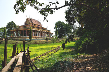 Wooden pier into pond with sunken boat at temple Wat Krabi Riel Pagoda, Siem Reap Province, Cambodia