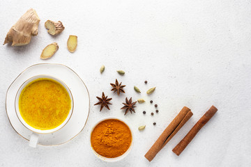 Ingredients for turmeric latte. Turmeric powder, curcuma root, cinnamon, ginger, badian over grey background, Spices for ayurvedic treatment. Alternative medicine concept. 