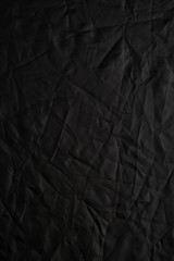 Texture of crumpled black fabric with a blue tint. Creative vintage background. Black flag.