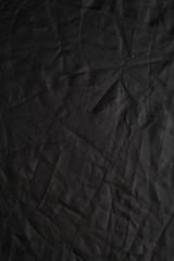Texture of crumpled black fabric with a blue tint. Creative vintage background. Black flag.