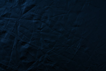 Texture of crumpled black fabric with a blue tint. Creative vintage background. Black flag.