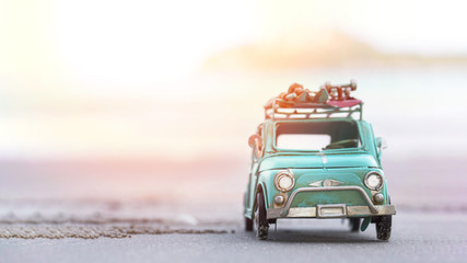 Miniature tin car closeup at summer beach scene