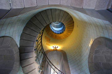 Looking up the spiral staircase inside the Eckmuhl lighthouse in Brittany, France - obrazy, fototapety, plakaty