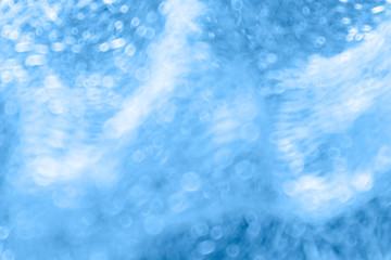 Abstract blue background with light waves and bokeh.