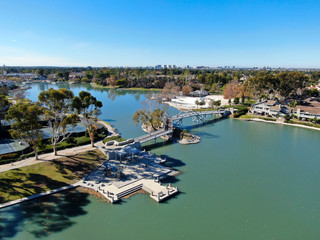 Fototapeta na wymiar Aerial view of North Lake surrounded by residential neighborhood during blue sky day in Irvine, Orange County, USA