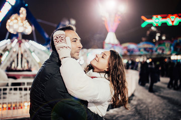 Loving couple walks in the evening in the winter city on a date, night lights.