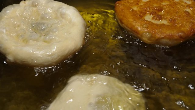 Langos being fried. Hungarian food speciality, a deep fried dough