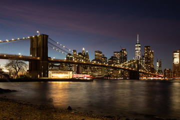 Fototapeta na wymiar NYC skyline including Brooklyn Bridge during a colorful dusk. 