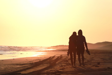 Fototapeta na wymiar pareja caminando al atardecer con el sol en las espaldas