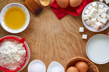 Ingredients for making pancakes on a wooden background    