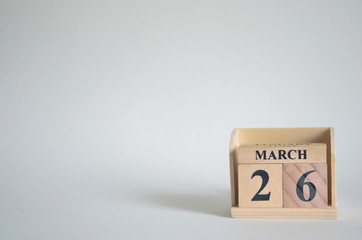 March 26, Empty white background with number cube on the table.
