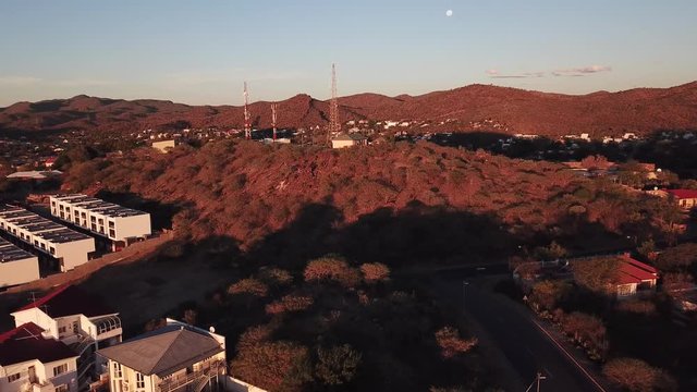 4K aerial Windhoek capital residential central hilly district bright sunset drone video with upmarket houses and old white walls German mansion on top of hill in Khomas Region, central Namibia