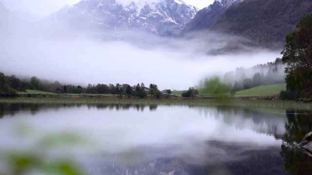 Beautiful lake with reflection of huge snowy mountains in background. Calm and mysterious landscape.