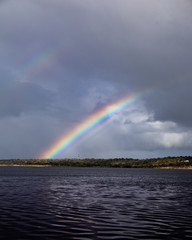 bright double rainbow over water