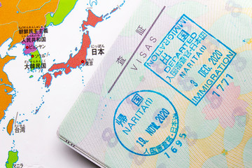 An inside page of a passport on a entry stamp to Japan with an Asian map on the background