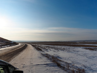 winter country road in the snow covered steppe and clear blue sk