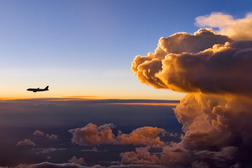 A Storm Front at Sunset with an Airplane in front of the storm