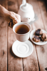 The woman's hand grabs the teacup and raises it.