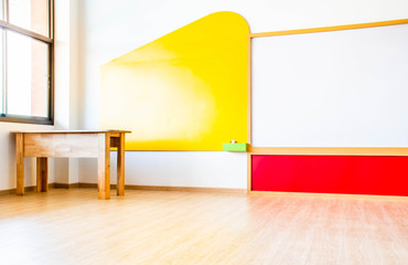 Beautiful kindergarten classroom that has colorful white board and table in the  class.