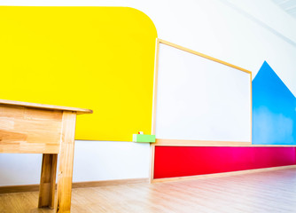 Beautiful kindergarten classroom that has colorful white board and table in the  class.