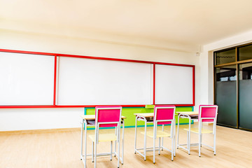 Desks, chairs and white board in the kindergarten classroom.