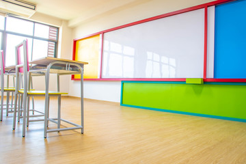 Desks, chairs and white board in the kindergarten classroom.