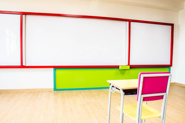 Desks, chairs and white board in the kindergarten classroom.