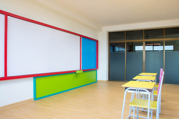 Desks, chairs and white board in the kindergarten classroom.