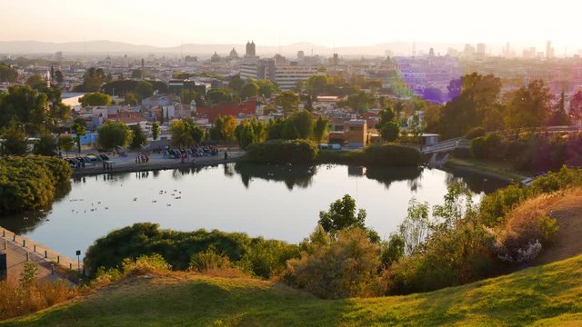 Panoramic view of Puebla de Zaragoza and lake la Concordia seen from the Mirador de Los Fuertes de Loreto with orange sky at sunset