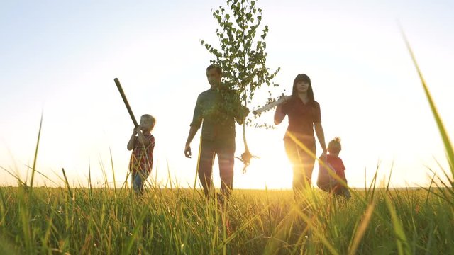 agriculture red neck farming happy family walking agriculture of farmers a silhouette concept slow motion video. lifestyle mom dad son and daughter walk go children happy family plant and water the