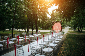 Arch decorated with fresh flowers and fabric for wedding ceremony outdoor. Solemn wedding...