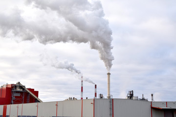 Ecology. Thick smoke comes out of the pipes of a modern industrial enterprise