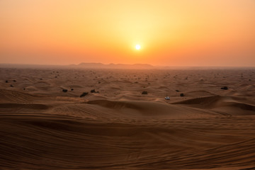 car amidst dunes during sunset