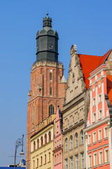 Obraz premium St. Elizabeth's Church tower overlooking some colorful buildings on Wroclaw's market square (Rynek) in Poland
